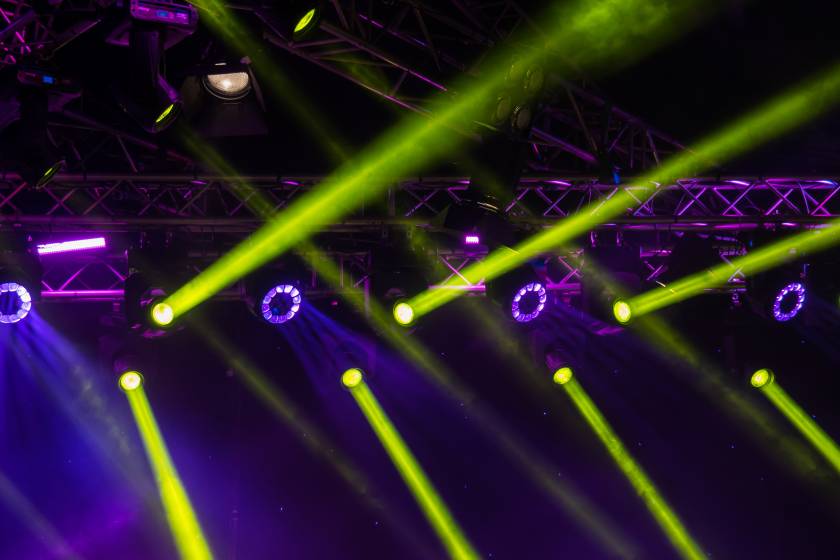 blue luminous rays from concert lighting against a dark backgrou