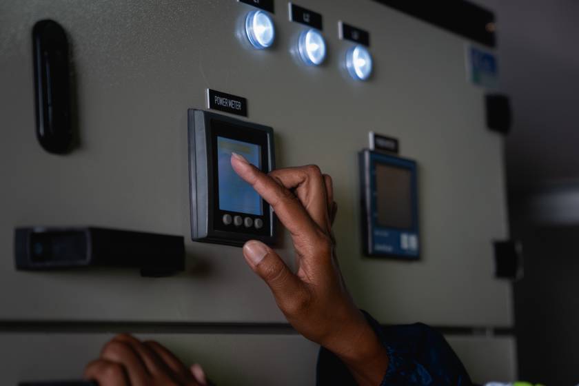 Hand of Technician is touching a switch on a power box