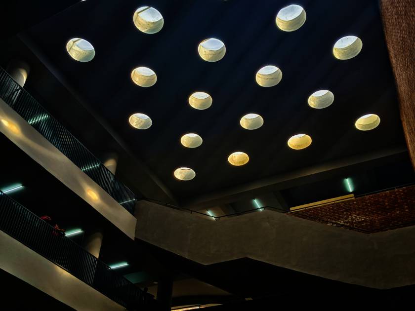 some round lights are on the ceiling over a building area