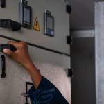 Hand of Technician is touching a switch on a power box