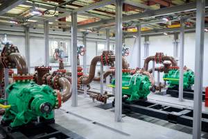 Wide angle shot of empty factory workshop with pipes and mechanisms, copy space