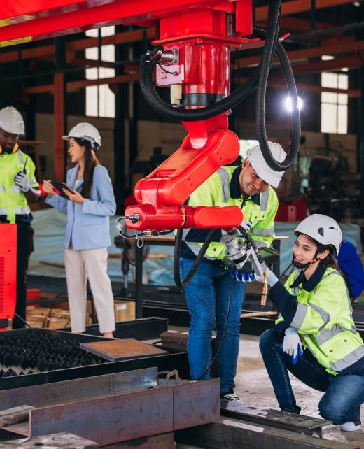 Engineers inspecting and check up machine of the automated arms machine welding robots at factory. Technician controlling the automated arms machine welding robots.