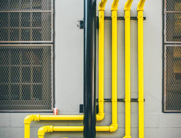 Many yellow pipes at exterior of a city building